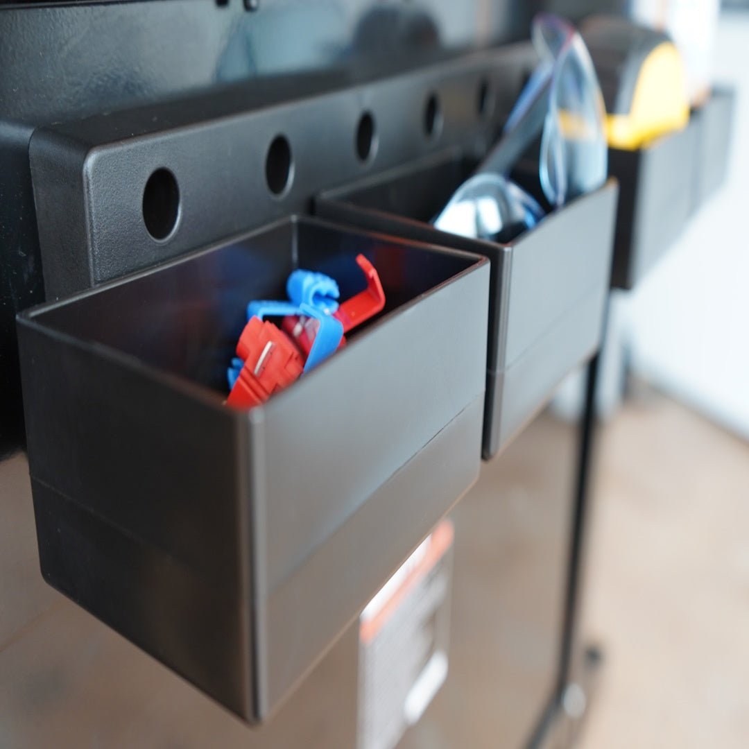 Black storage bin with red and blue items on a reflective surface