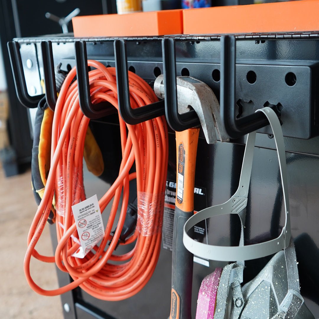 Wall-mounted tool holder with tools and extension cord in a workshop setting